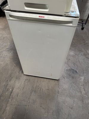un réfrigérateur blanc posé au milieu d'une pièce