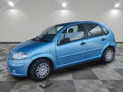 a picture of a small blue car parked in a garage