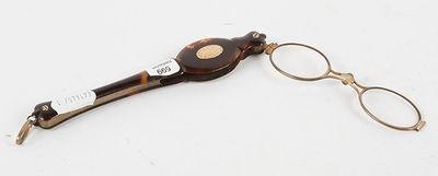 pair of eyeglasses and a pair of scissors on a white surface