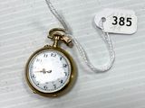 a gold pocket watch with a white face on a string