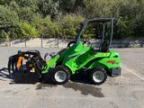 un petit tracteur vert garé sur un parking