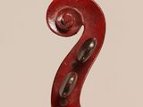 a close up of a red violin with a wooden stick