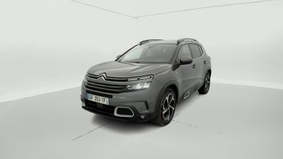Une Citroën grise est garée dans une pièce blanche