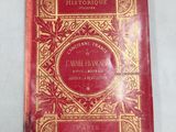 an old red book with gold writing on it sitting on a white surface