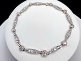 une assiette blanche sur laquelle sont posés un collier et un bracelet