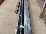 several steel pipes are lined up in a warehouse area