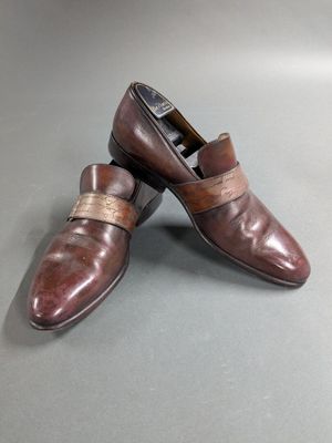 pair of men ' s brown leather shoes on a grey surface