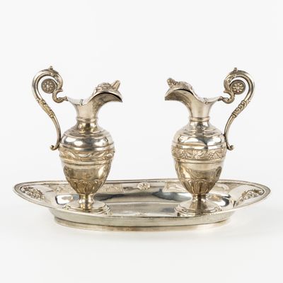 paire de vases argentés munis d'anses, posés sur un plateau