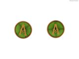 un gros plan sur une paire de boucles d'oreilles sur fond vert