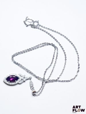 collier avec une pierre violette et une chaîne en argent sur fond blanc
