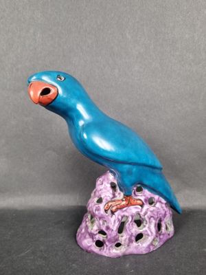 Perroquet en porcelaine polychrome, posé sur un rocher percé…