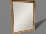 a gold framed mirror sitting on top of a gray surface