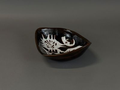 un bol noir et blanc orné d'un motif de poisson