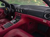 a red sports car inside of a car with red leather seats