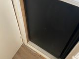 a black refrigerator in the corner of a kitchen