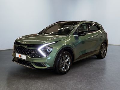 Le SUV vert est garé dans une pièce aux murs blancs.