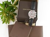louis vuitton men ' s watch in a box next to a plant