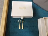 two pairs of earrings in a box on the floor