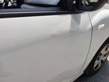 a small white car parked on the side of the road