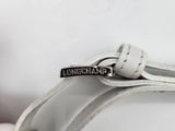 a white purse that has a silver buckle on it