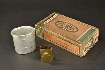 a box of cigars and a cup on a table