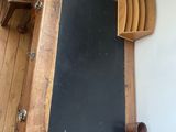 a chalk board on the wall next to a wooden shelf