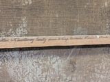 a piece of wood with writing on it sitting on a piece of cloth