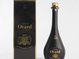 a bottle of ouard is next to a box on a white surface