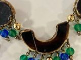 an image of a close up of a necklace on a white surface