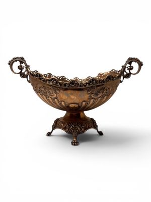 an ornate bronze bowl on stand on a white background
