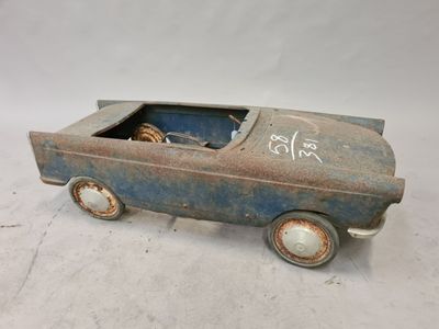 une vieille petite voiture décorée de graffitis, posée sur une surface blanche