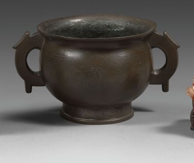 une petite figurine d'un homme debout à côté d'un vase