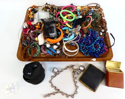 un plateau en bois rempli de bijoux variés, posé sur une surface blanche