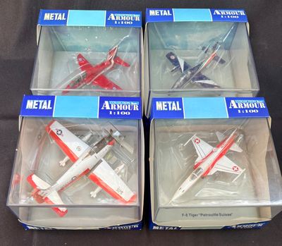 quatre maquettes d'avions en plastique se trouvent dans une boîte posée sur une surface noire