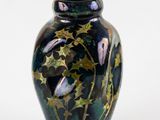 a black vase with gold stars on it on a white background
