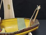a small wooden boat with a paddle on a black background