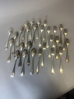 beaucoup de cuillères et de fourchettes en argent sur une table