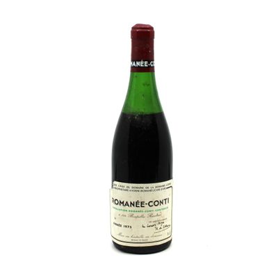 the bottle of wine is sitting on a white surface