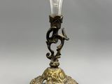 un bougeoir ancien en laiton et en verre, orné d'un oiseau