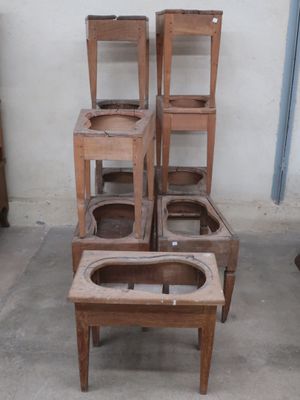 several wooden chairs stacked on top of each other in a room