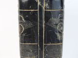 two black vases with gold trims on each of them