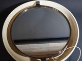 un miroir rond accroché au mur, à côté d'une table