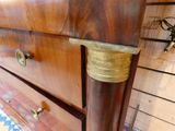 a wooden dresser with a brass handle on it