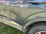 a close up of a car ' s side door with a reflection of a building