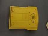 a yellow telephone sitting on a table next to a cell phone