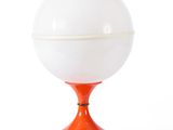an orange table lamp with a white globe on top of it