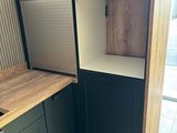 a kitchen with a wooden counter top and black cabinets