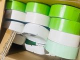 many rolls of green and white tape in a box