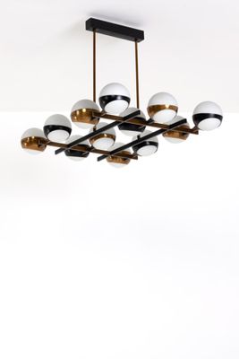 une photo d'un lustre moderne avec des éléments noirs et dorés