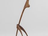 une sculpture en bois représentant un oiseau sur fond blanc